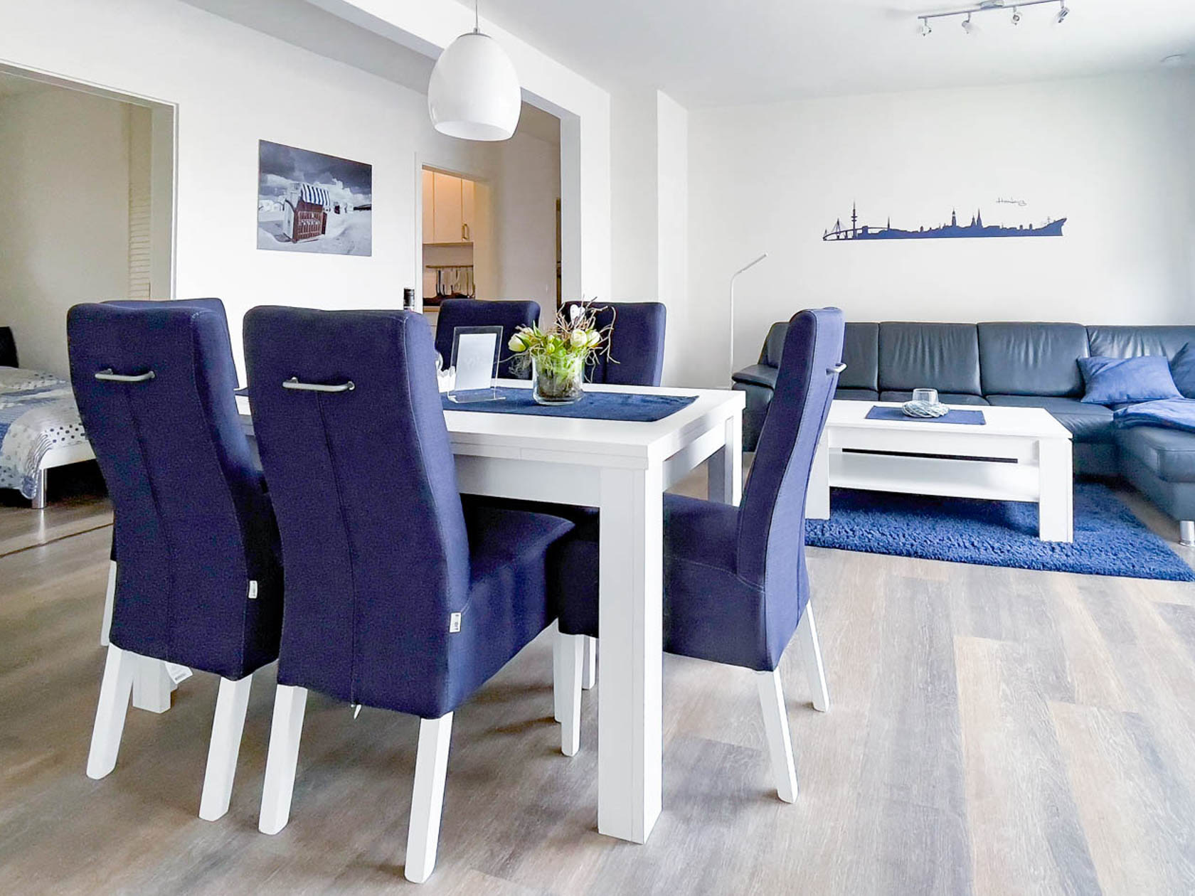 Hell und freundlich eingerichtetes Wohnzimmer der Ferienwohnung Strandkorb mit Zugang zur Terrasse